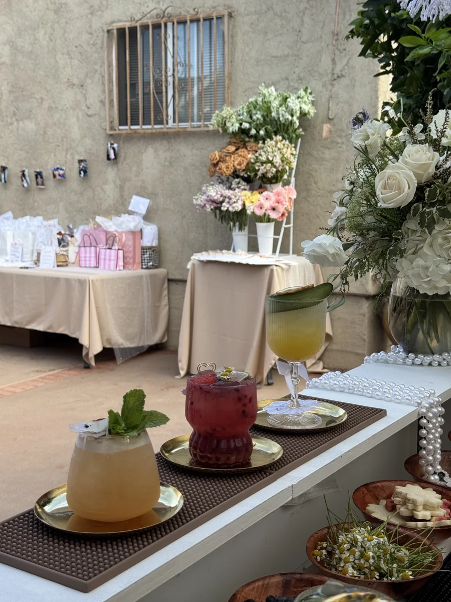 Three cocktails beside white floral event decorations